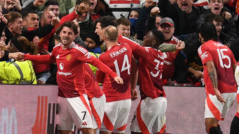 Manchester United's English defender #05 Harry Maguire (C) and teammates celebrate with their fans after Maguire scores their fifth goal during the UEFA Europa league quarter-final final, second leg football match between Manchester United and Lyon a